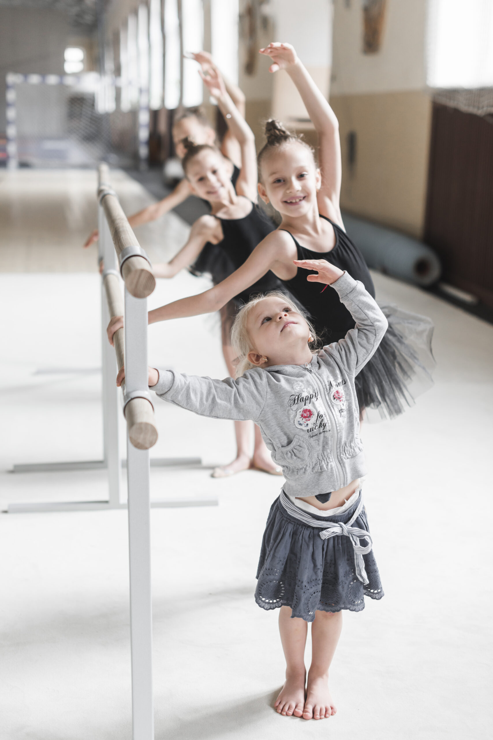 cute girl practicing ballet dance with her sister dance studio scaled